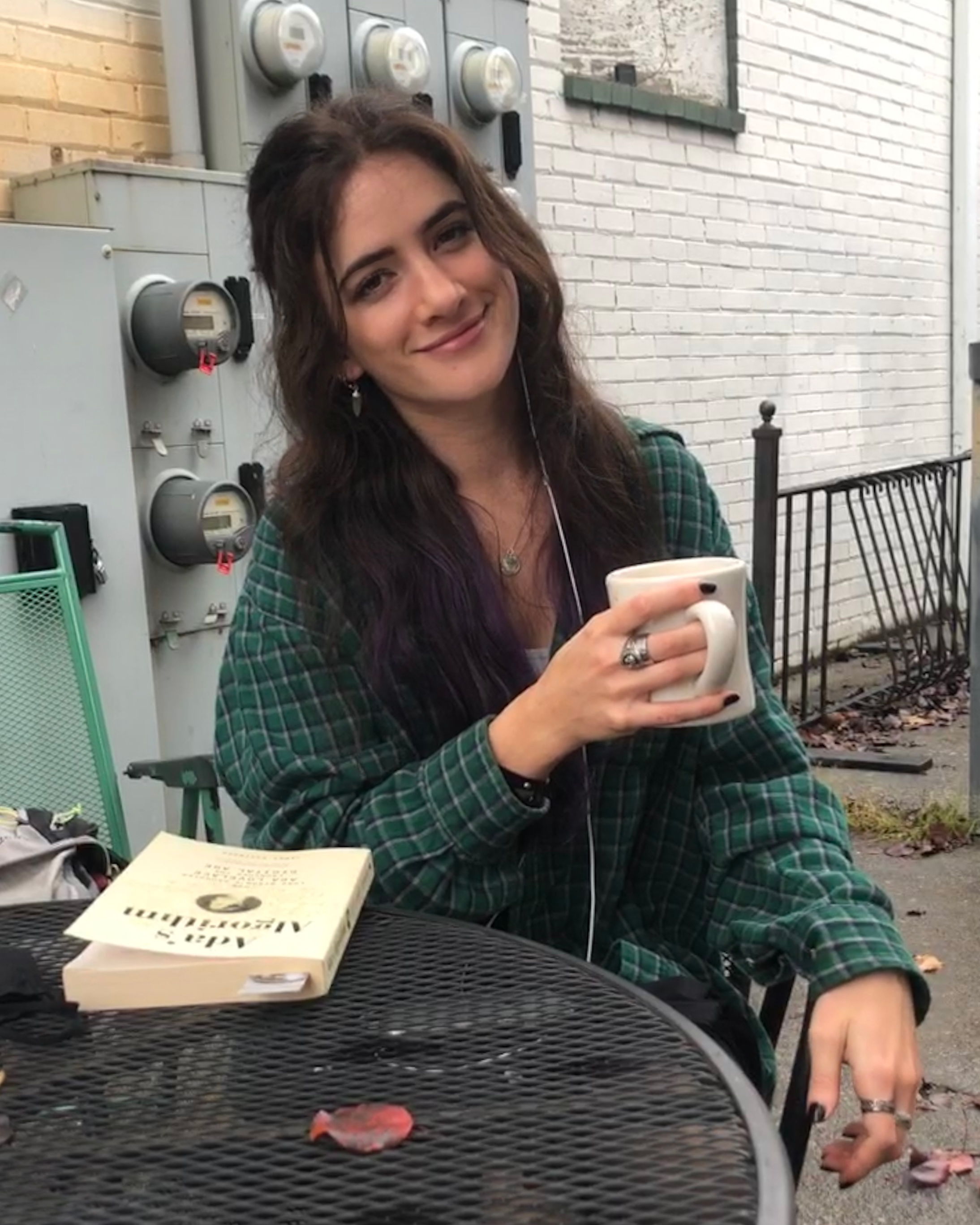 Leah sitting outside holding a coffee cup